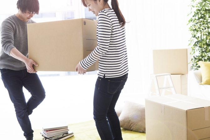 Couple are carrying a cardboard box